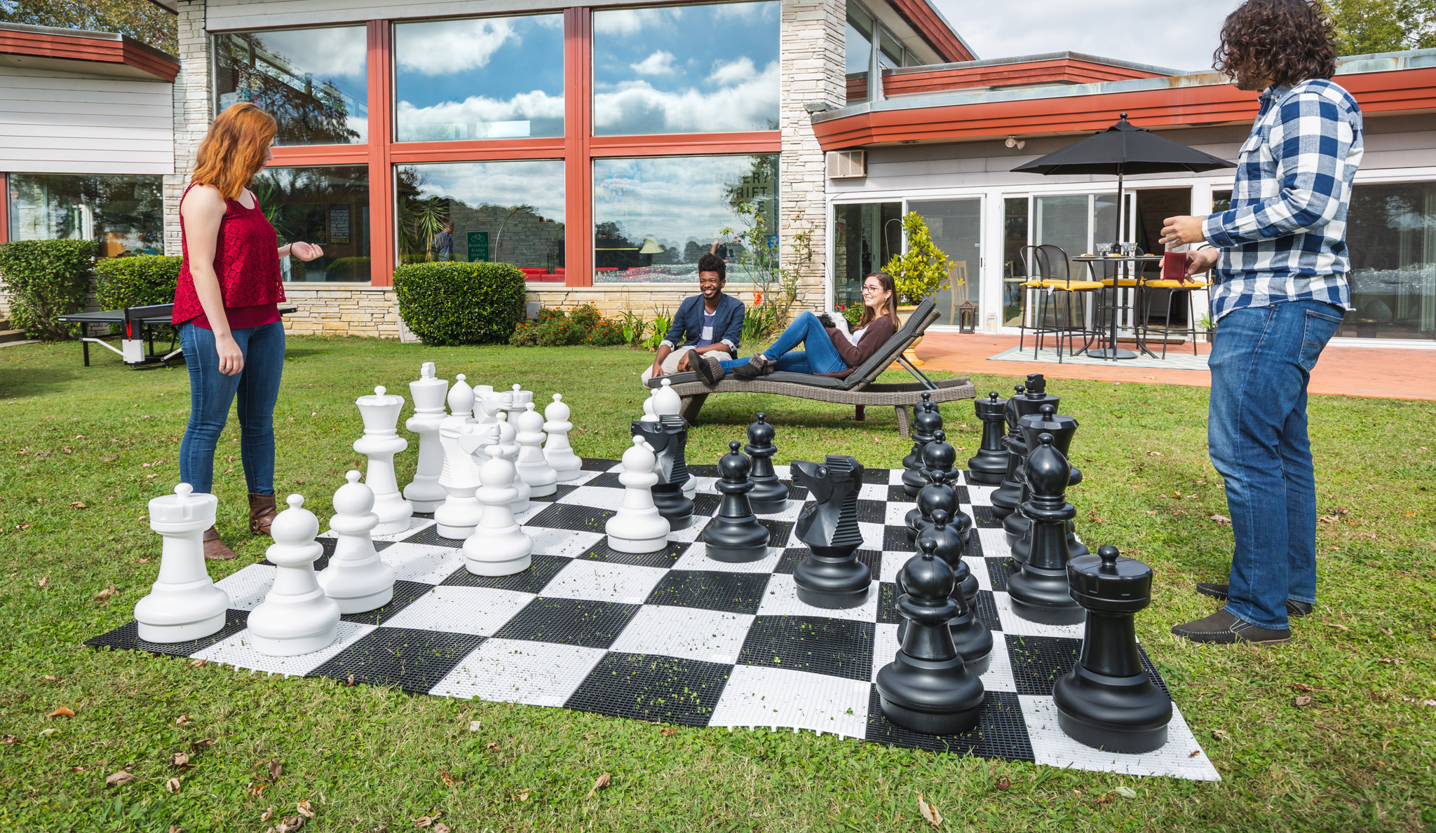 KETTLER Outdoor Games image of people playing outdoor chess in a yard
