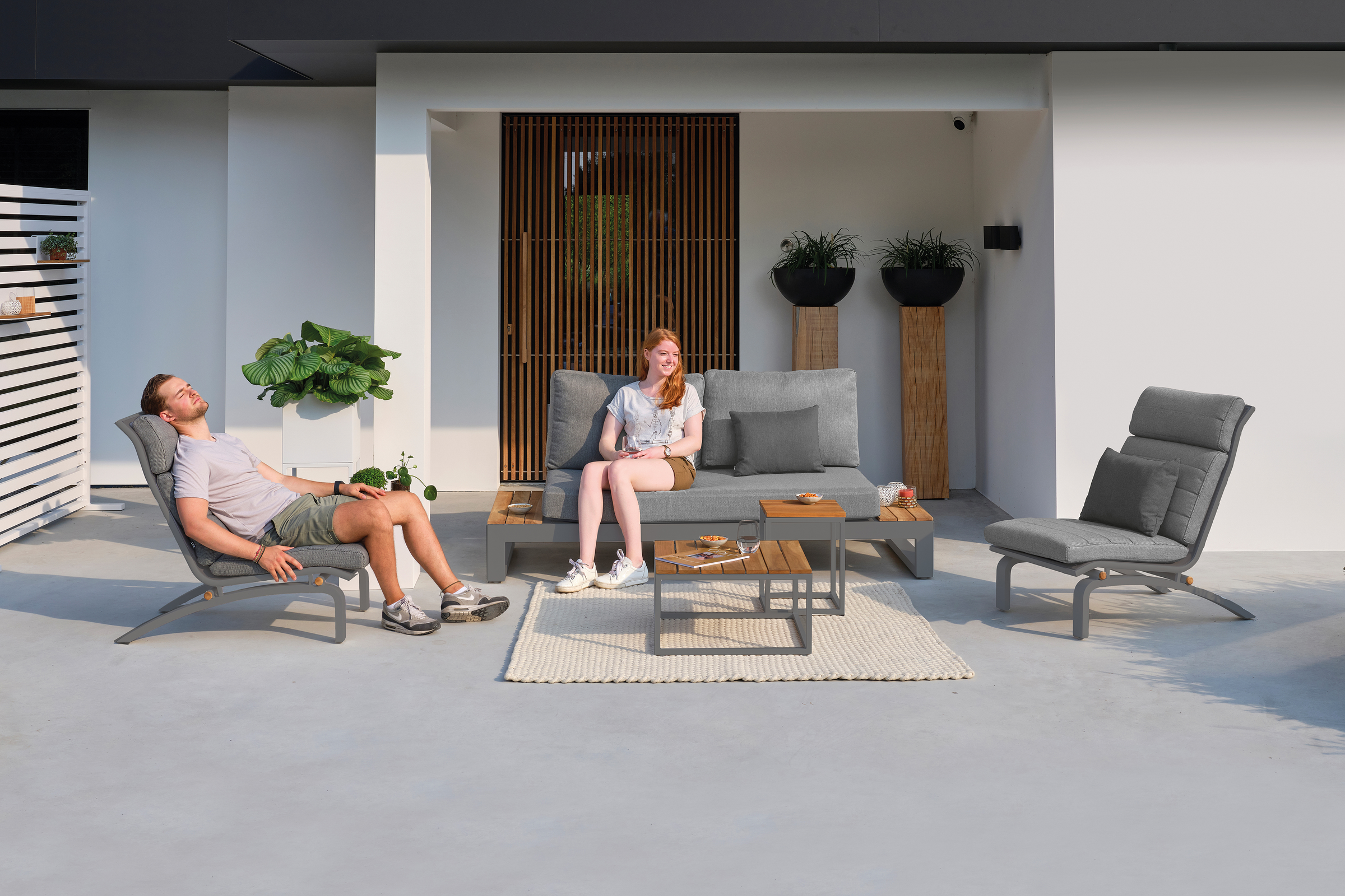 KETTLER Patio Furniture image of a man and woman lounging outside on the Soho lounge set.