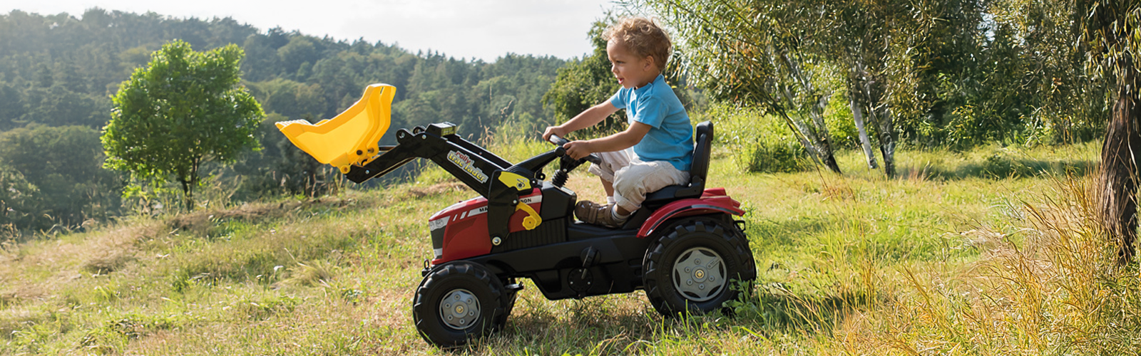 young boy riding red tractor