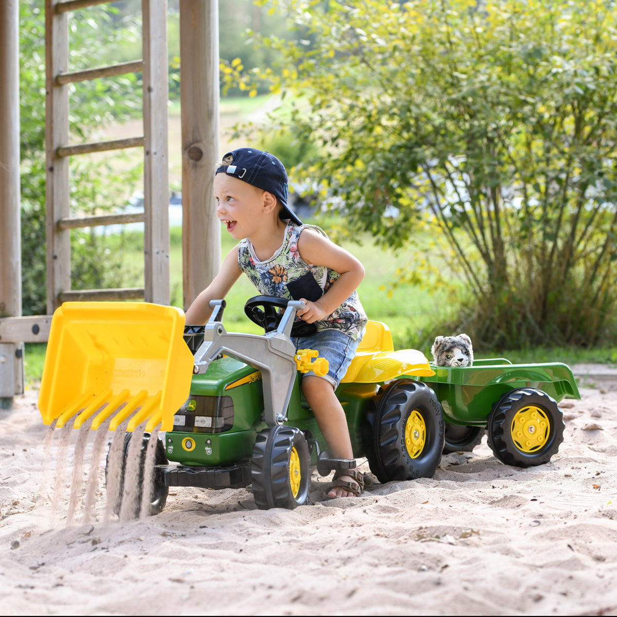 Child playing on the John Deere Made in Germany Pedal Tractor with trailer and front loader 