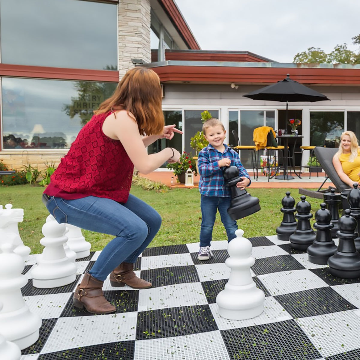 Family playing with the giant chess set outside
